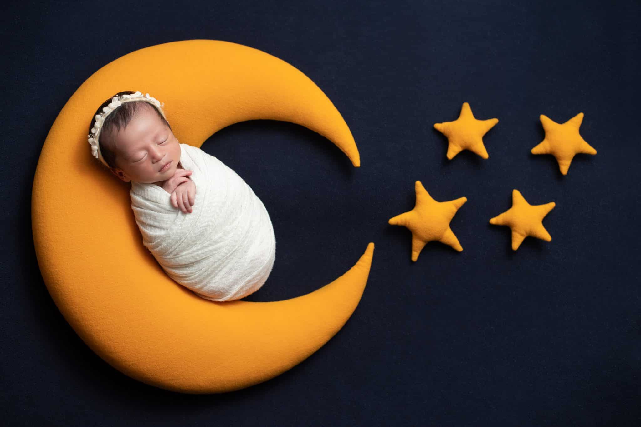 Creative moon prop newborn portrait with sleeping baby photographed by a Toronto newborn photographer