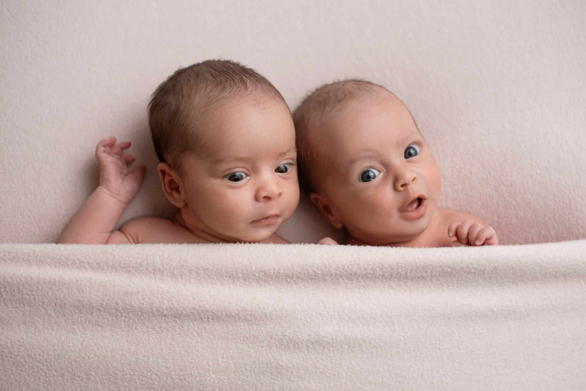 Twin newborn babies posed together during a natural newborn photography Toronto studio portrait