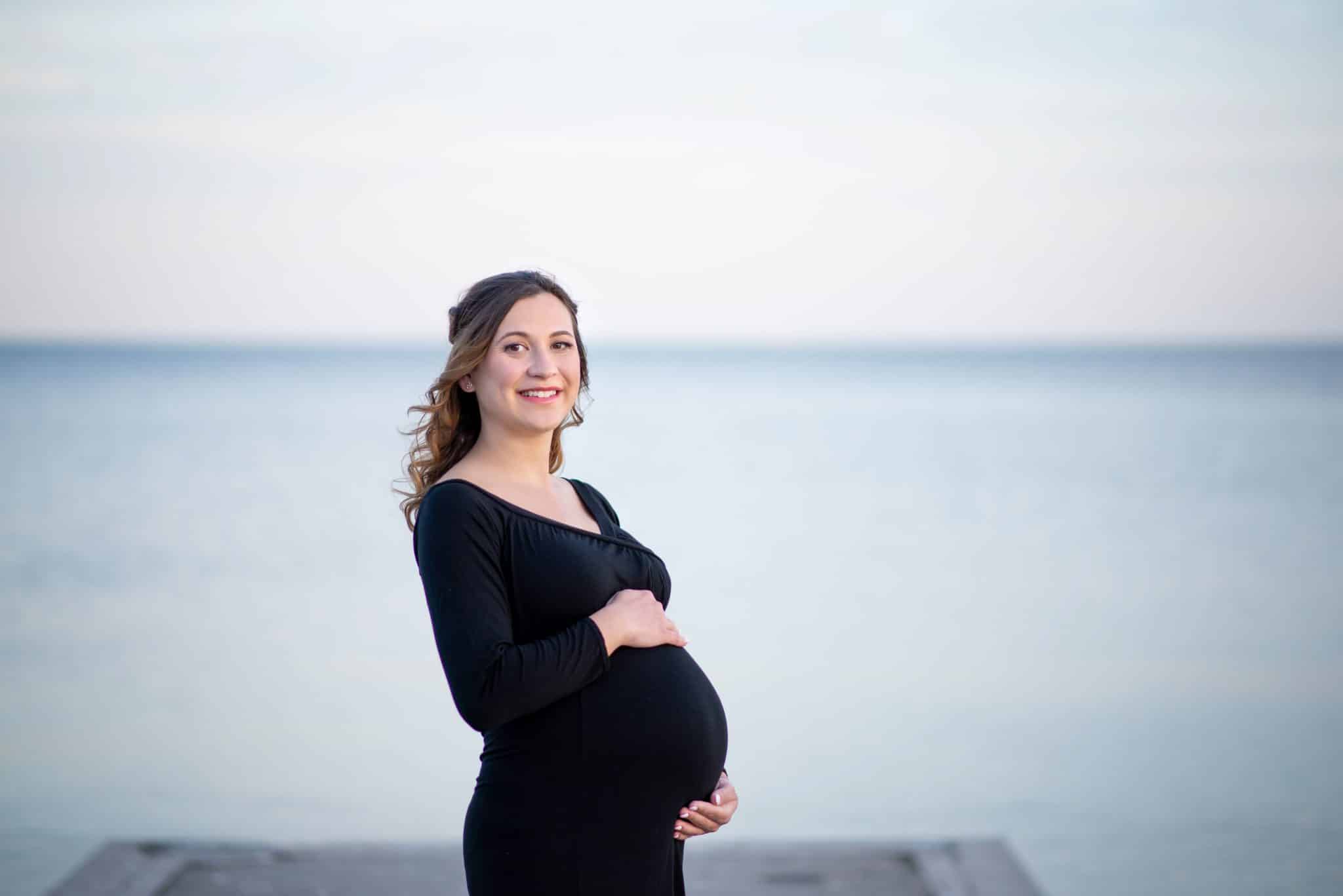 Elegant maternity photography in Toronto waterfront, expecting mother portrait with calm lake background, natural pregnancy photoshoot.