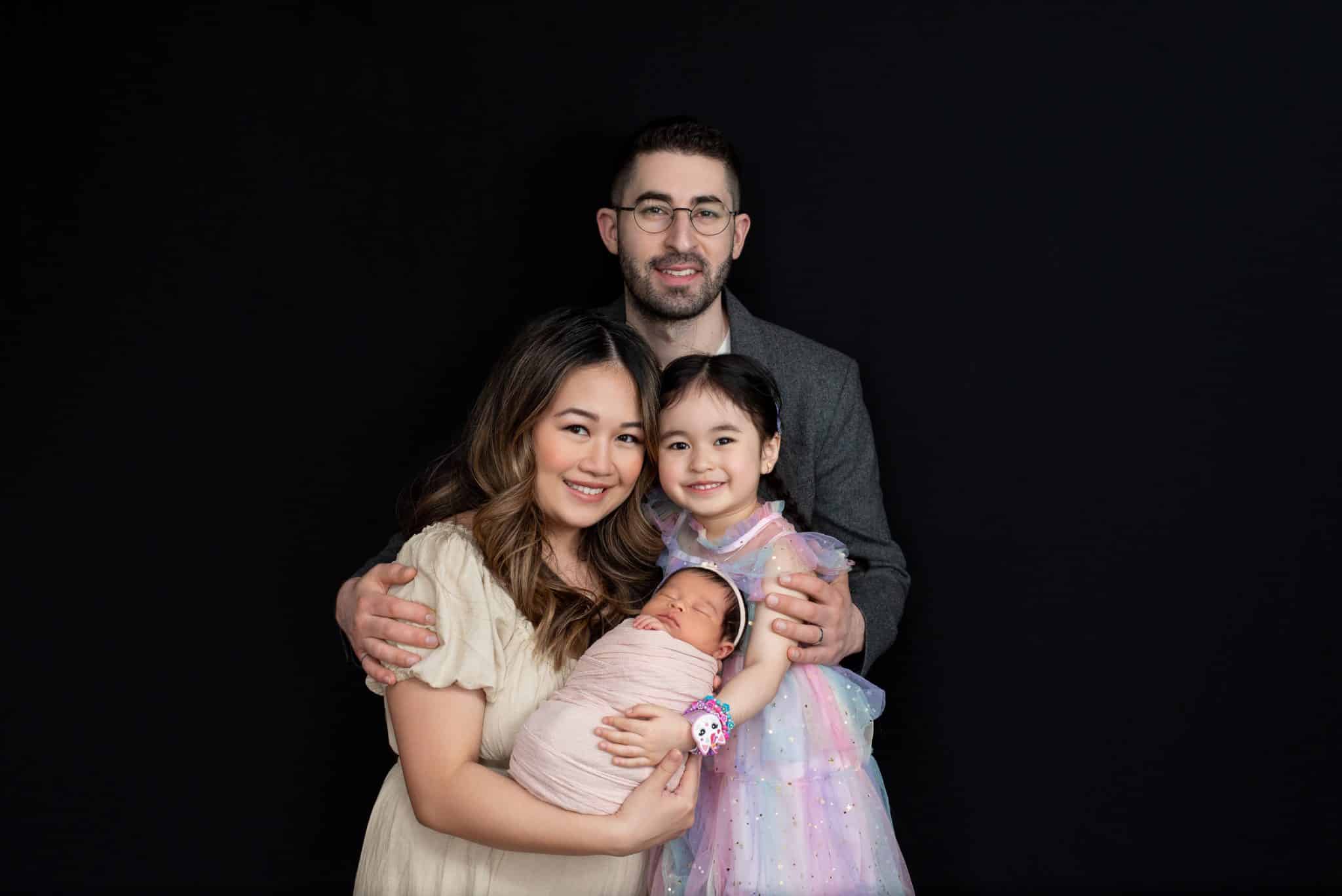 Beautiful family portrait with parents, sibling, and newborn baby during a Toronto newborn photography session