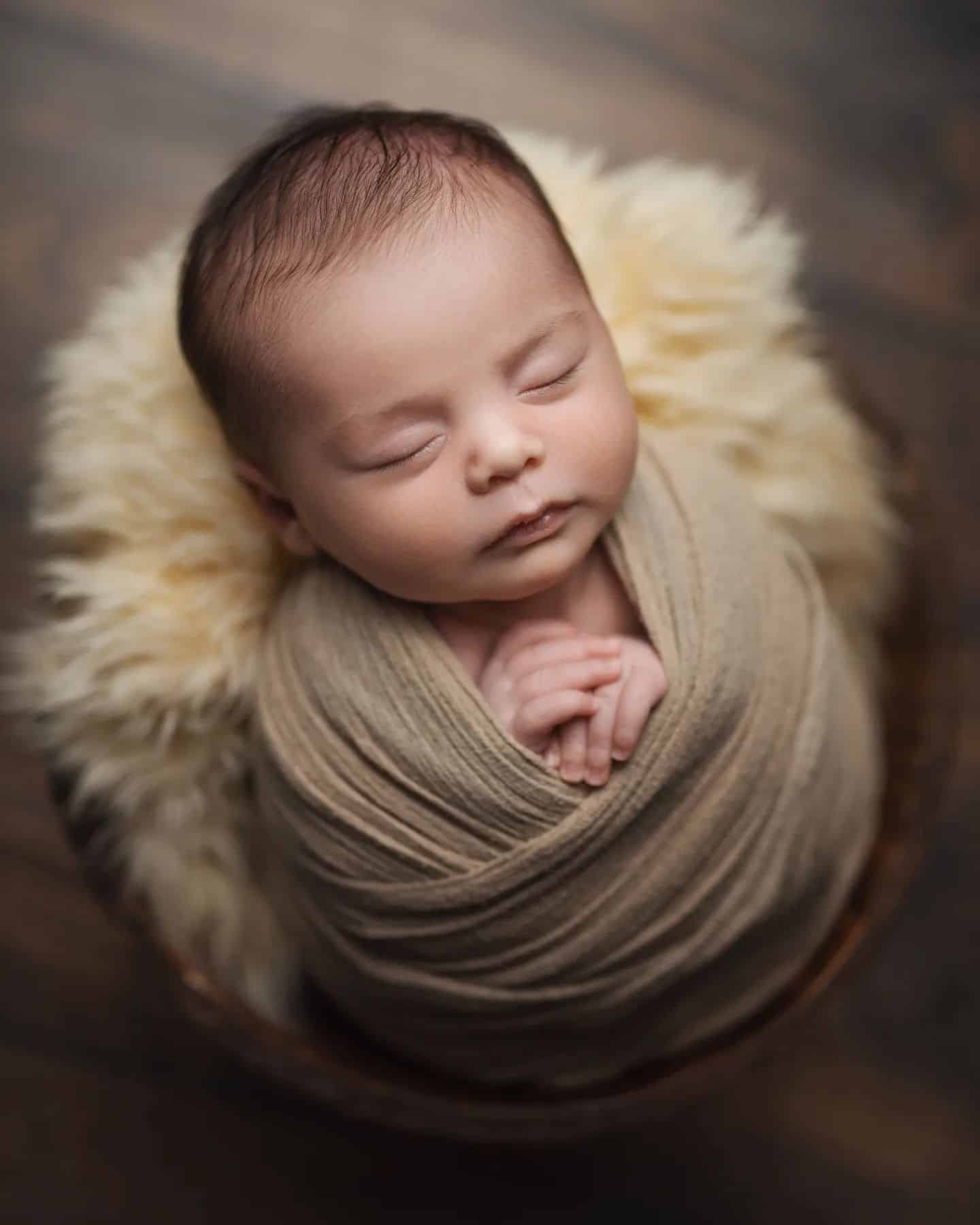 Peaceful newborn baby wrapped in light brown, ideal for newborn photography Mississauga sessions