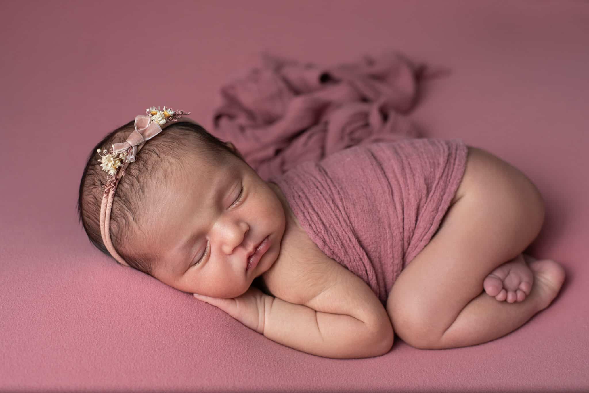 Adorable newborn photography Mississauga session with a baby wrapped in pink and a teddy bear, by a top baby photographer Mississauga.