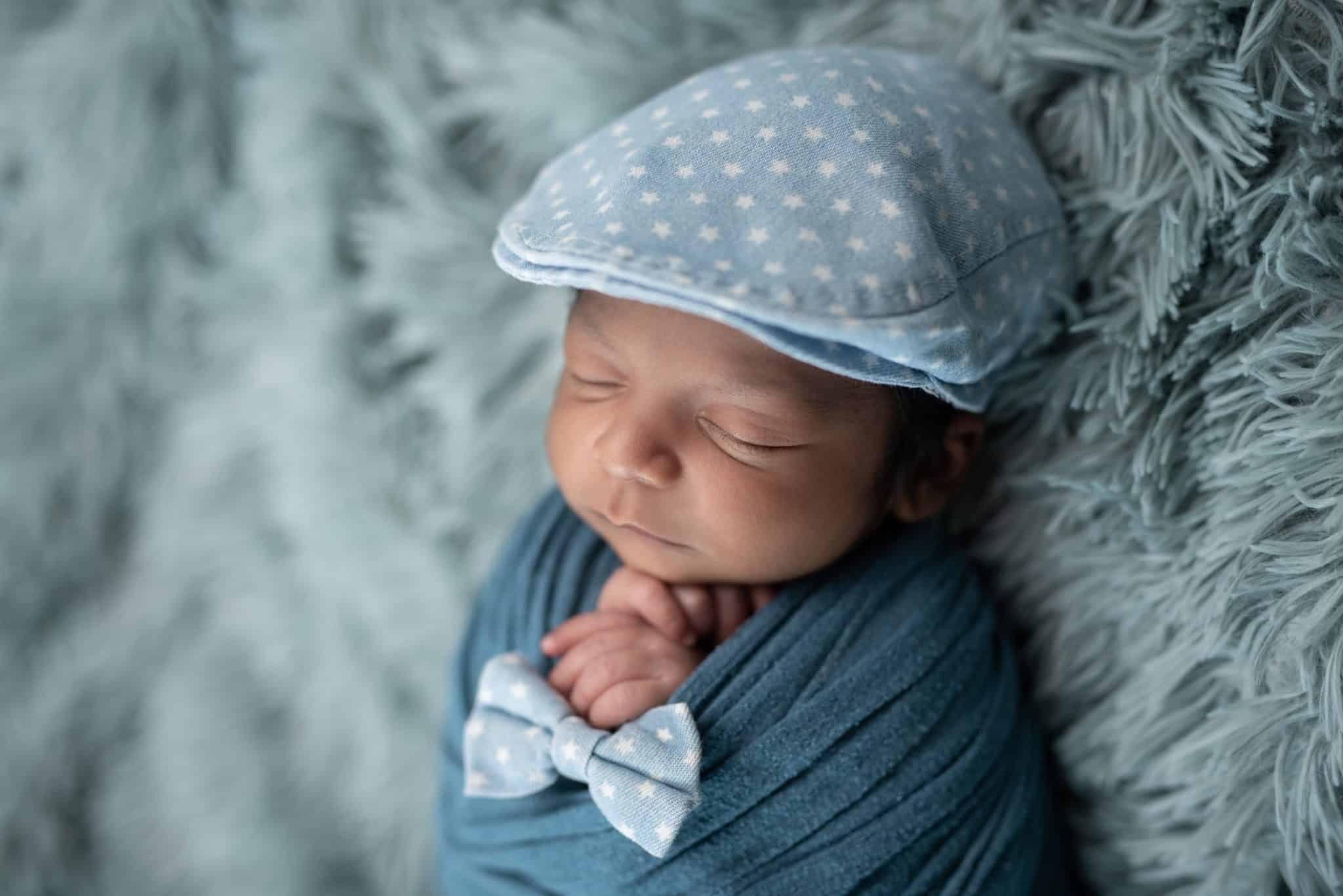 Cute newborn baby in a blue hat and wrap, perfect for a baby photographer Mississauga.