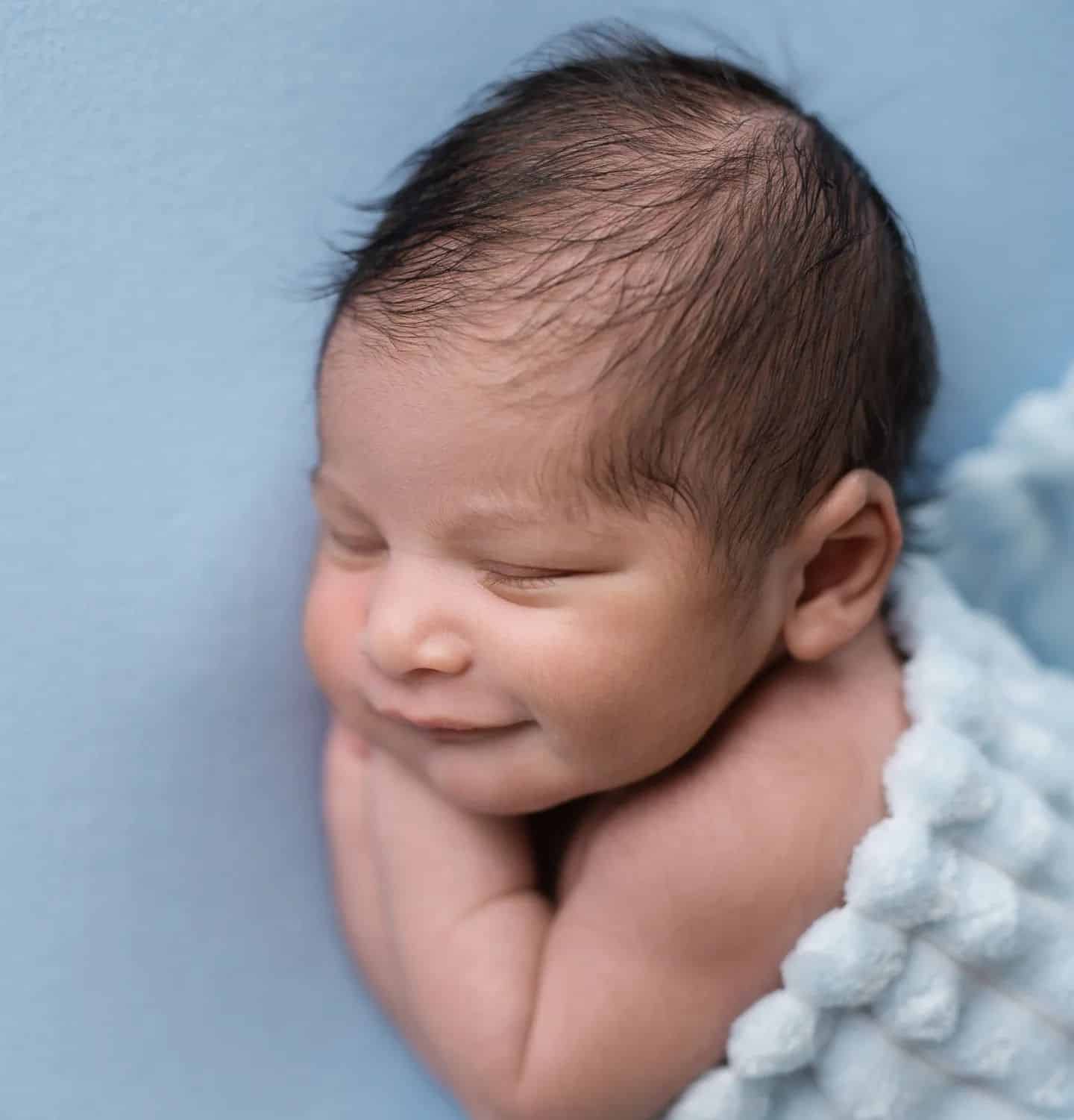 Sweet newborn baby sleeping on a soft blue blanket, perfect for baby photography Mississauga.