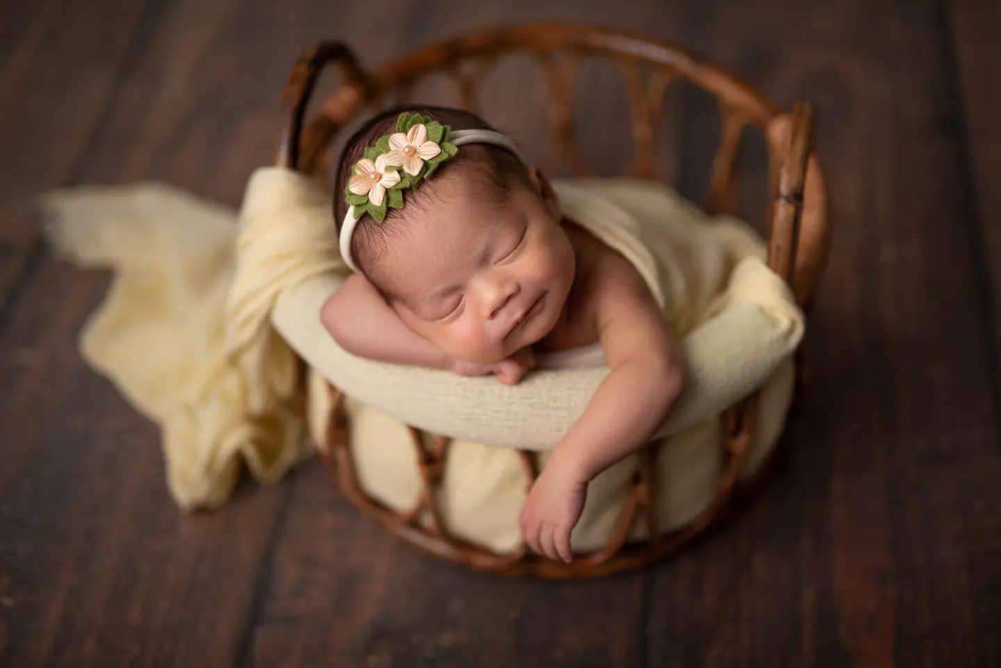Newborn photographer Toronto – sleeping newborn baby wrapped in soft beige wrap on rustic backdrop