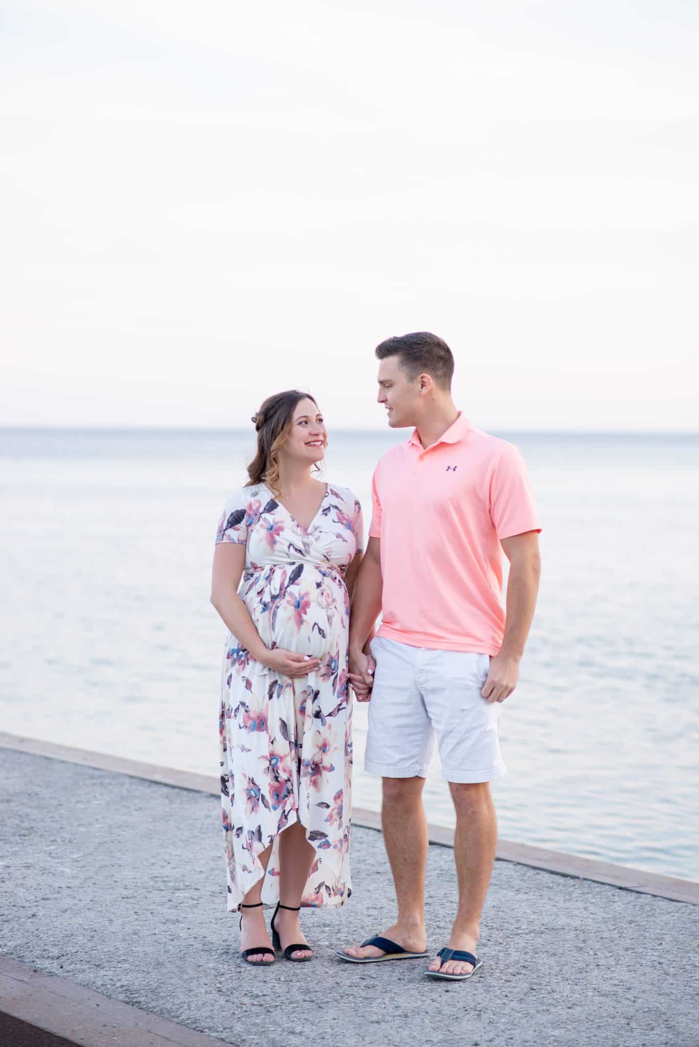 Couple maternity photoshoot by the lake, pregnancy photography in Toronto waterfront location, natural outdoor romantic maternity session.