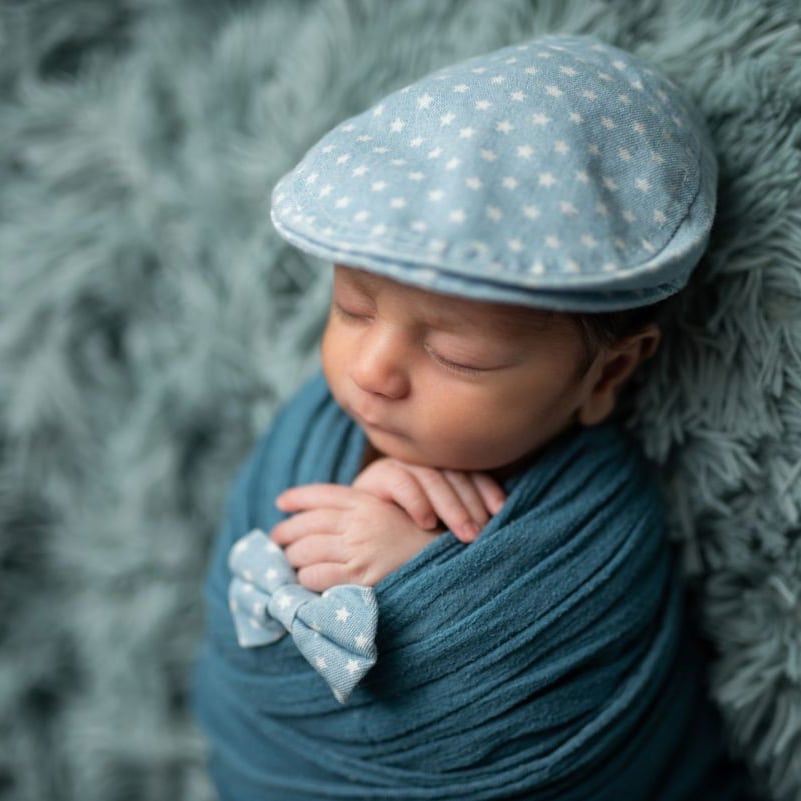 Toronto twin newborn photography with sleeping babies wrapped together on rustic wooden bed setup