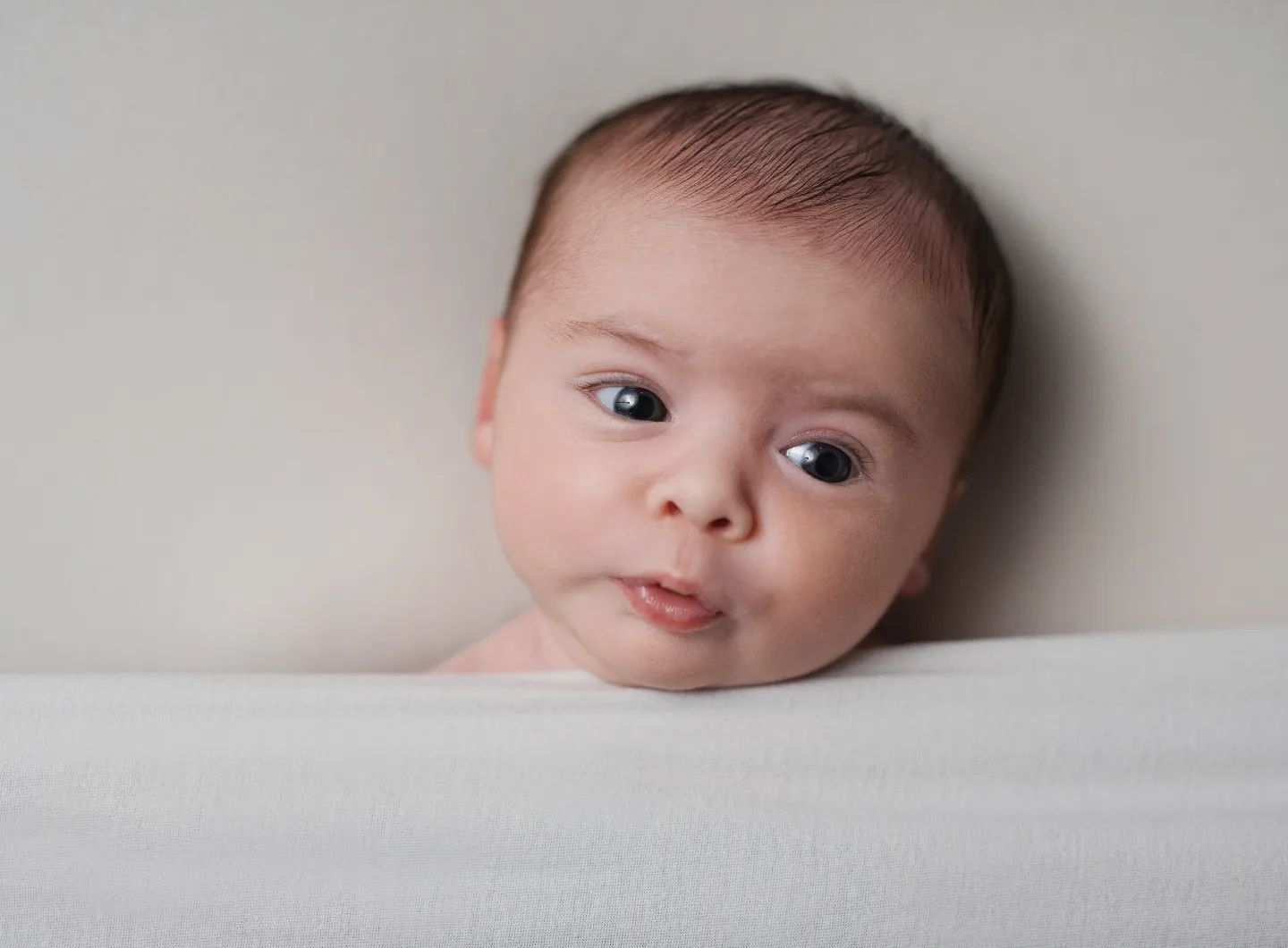 Newborn photoshoot Toronto – close-up portrait of alert newborn baby with soft natural lighting
